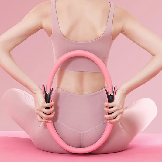 Person holding a pink exercise hoop against a pink background